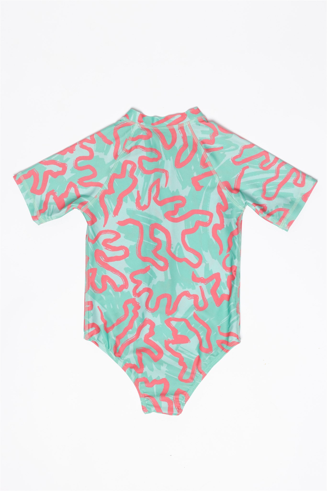 The Girls Badeanzug kurzarm - CORAL by kindischworld.com is a short-sleeve one-piece swimsuit for children, made from recycled polyester, with a mint green base and pink abstract patterns, shown flat on a white background.