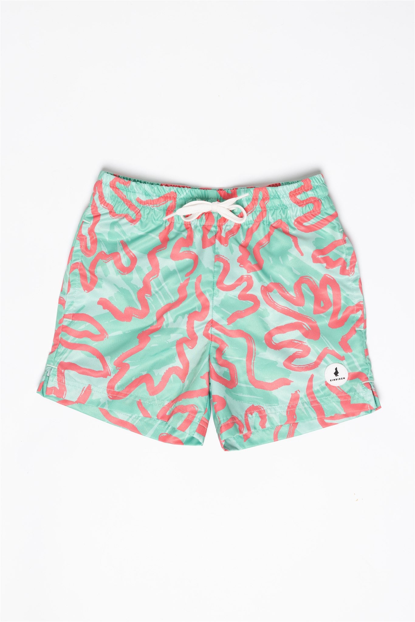 Die Badehose - CORAL für Jungs von KINDISCH ist aus recyceltem Polyester, grün mit rotem Korallenmuster, weißem Kordelzug und schnelltrocknend – präsentiert auf weißem Hintergrund.