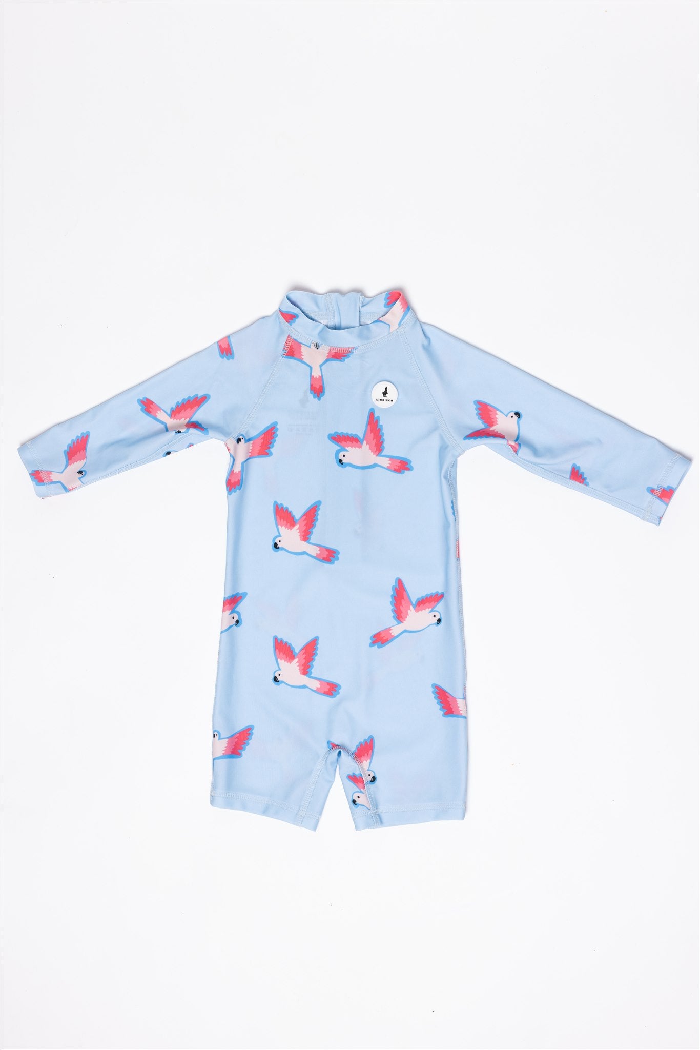 The Baby Badeanzug - PARROT by kindischworld.com is a light blue, long-sleeve swimsuit with pink and white birds, offering UPF50+ UV protection and shown flat on a white background.